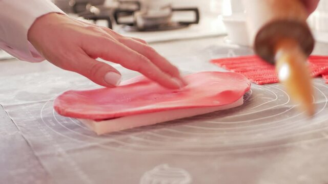 confectioner rolls out dough, mastic for decorating cake, pastries. pattern shape