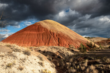 Clouds and sunset light over red hill