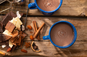 Festively served coffee table - two blue cups of coffee, pieces of chocolate and decor on a wooden background. Low angle view. Home comfort, the spirit of Christmas, Valentine's Day.