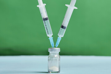 A covid-19 vaccine vial with syringes. Covid-19 vaccine booster dose. Booster shot of new...
