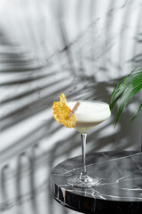 pina colada cocktail with shadow on jight backround. Pina Colada cocktail with decorations on marble table light background