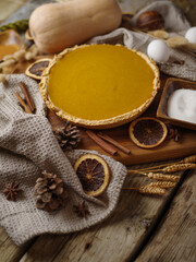 Original composition - festive American pumpkin pie and decor. Large group of objects. Wood texture. Halloween, Thanksgiving, Christmas, Birthday, family gatherings and celebrations.