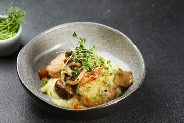 mashed potatoes with cutlets and mushrooms in ceramic plate. mashed potatoes with microgreen on dark concrete table