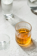 Whiskey in a glass among glasses with water white background 
