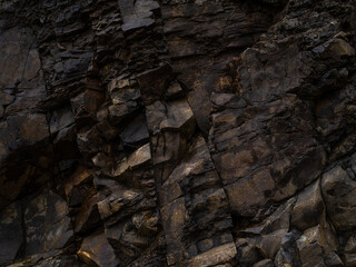 Macro photography. Stone texture composed of small fragments. Dark tones. Construction work, geology, ecology, minimalism. There are no people in the photo.