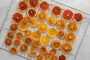 Oven dried sliced slices of orange, tangerine and grapefruit, dried citrus fruits on a wire rack,...