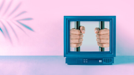 Abstract surreal scene with shadow of a tropical palm leaf and mans hands and prison bars in the retro vintage television box. Retro futurism. Creative minimal conceptual cyberwave background. 
