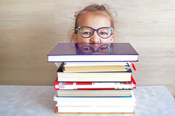 Schoolgirl girl reads books after school to know a lot