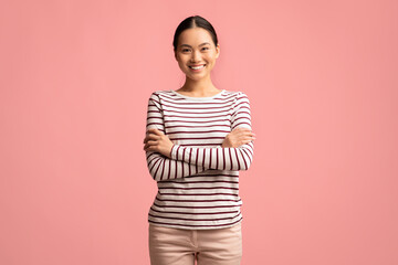 Fototapeta premium Portrait Of Young Confident Smiling Asian Woman Standing With Folded Arms