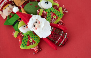 Fabric christmas Ornament decoration in classic colors green and red against red background. santa claus, snowman, elf. Horizontal and copy space