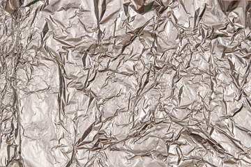 Silver shiny crumpled foil texture background. Top view