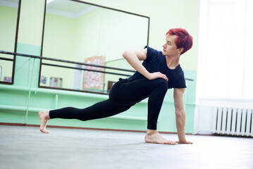 Stretching before intensive lesson of dancing. Young male dancer preparing for the lesson in...