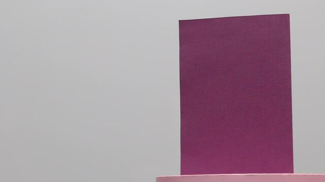Making greeting cards. Paper blanks, ribbons and lagurus branches. Stands on a rotating stage. On white background.