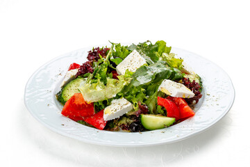 Greek salad with fresh vegetables and feta cheese. Isolated on a white background