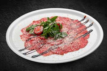 Veal carpaccio with parmesan cheese. Isolated on a black background