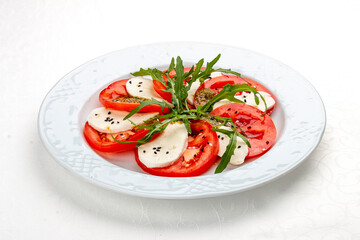 Caprese salad with mozzarella, tomatoes and pesto sauce. A traditional Italian dish. Isolated on a white background.