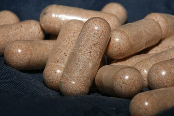 Transparent capsules filled with brown vitamins powder close up background high quality big size prints