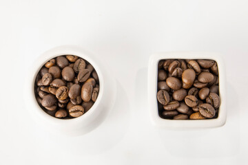 Coffee beans in jugs on a white background