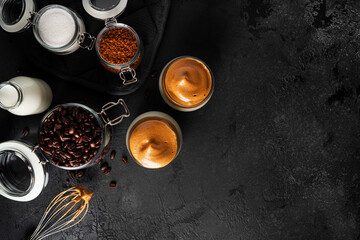 Obraz na płótnie Canvas Dalgona coffee on a dark background. Coffee composition. Coffee with foam. Coffee time. Coffee break. Coffee in a clear glass.