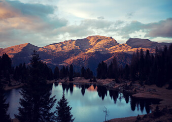 sunset on the lake's shore on dolomites
