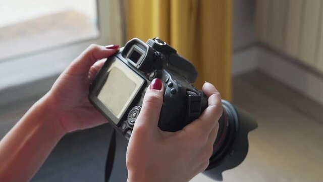 Woman checking reflex camera after taking a photo session