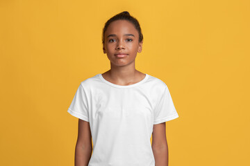 Serious calm teen afro american girl pupil in white t-shirt looking at camera alone