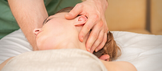 Fototapeta na wymiar Osteopath doing massage on the female head in rehabilitation clinic center