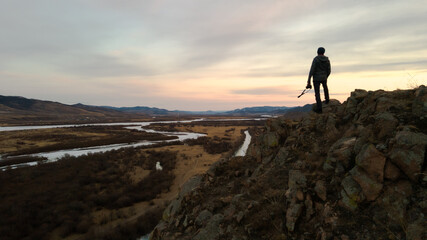 Fototapeta premium silhouette of a person with camera standing on a mountain top