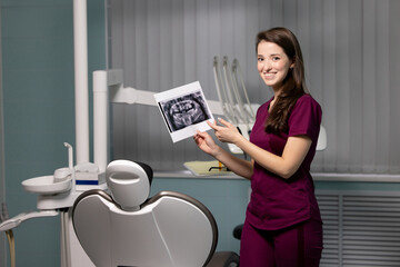Beautiful woman doctor with dental scans in hands in a dental clinic
