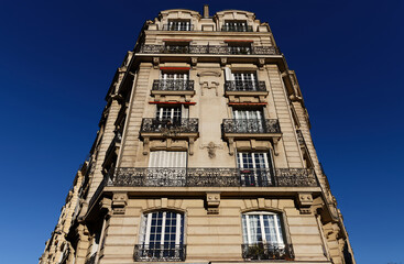 The facade of traditional French house with typical balconies and windows. Paris.