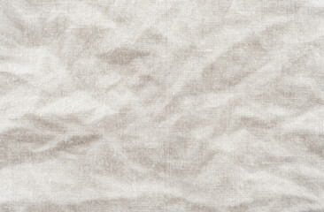 A crumpled piece of fabric with gray waves and folds. Sewing material. White canvas texture background with delicate striped seamless pattern