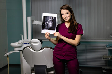Beautiful woman doctor with dental scans in hands in a dental clinic