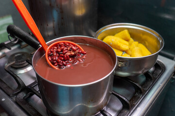 Cooking read beans and yellow plantain in a stove for traditional recipe of Central America and South America.