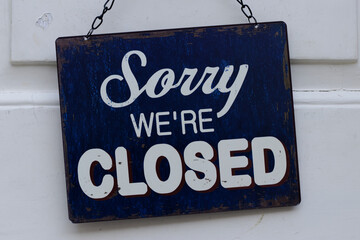 Sorry we're closed sign hanging on a store doors