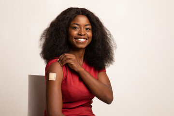 Vaccination. Smiling Black Lady Demonstrating Arm With Adhesive Bandage After Covid-19 Vaccine - obrazy, fototapety, plakaty