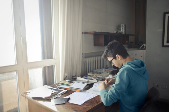 young boy studies in his bedroom