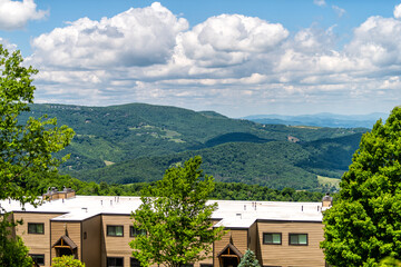 Fototapeta na wymiar Sugar Mountain ski resort town with view of beautiful green mountains in summer in North Carolina with condo apartment buildings on peak in Blue Ridge Appalachia