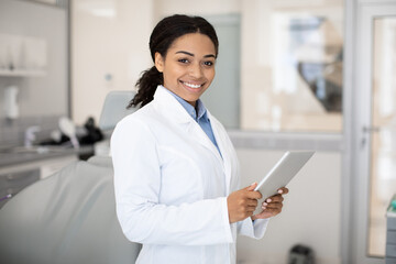Modern Dentistry. Portrait Of Smiling Black Dentist Female Doctor With Digital Tablet