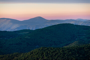 View from Sugar Mountain of sunset dusk ridge layers and peaks in North Carolina Blue Ridge Appalachias with silhouette, trees and pastel color