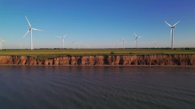 Windmills On A Cliff Above The Sea, Top View. Wind Farm With Turbine Cables For Wind Energy. Renewable Energy Source. Drone Video Of Onshore Wind Power Station, View From The Top, 4k. Botiyevska Ves