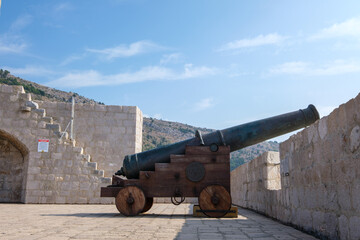 Fototapeta na wymiar Profile of an old cannon in Dubrovnik. Vintage war weapon for defense and protection. Medieval fort in Dubrovnik protected by guns.