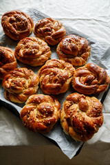 Homemade traditional cinnamon - cardamom sweet buns on a rustic table. Traditional Swedish baking Kanelbular.