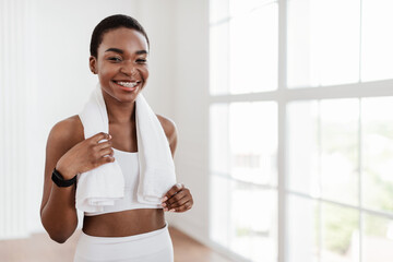 Happy sporty black woman in white sportswear posing