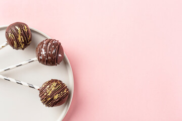 Chocolate cake pops on a pink background.