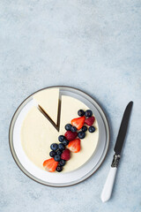 Top view of cheesecake with summer berries on light background.