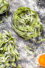 Obraz premium Raw homemade pasta and ingredients for pasta on dark background