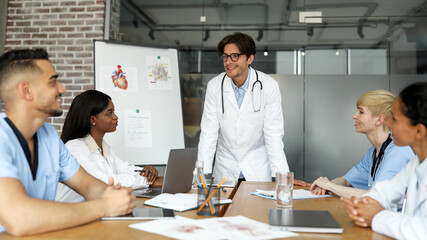 Smiling man chief physician making presentation for international colleagues