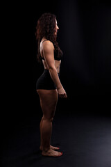 Fototapeta premium Portrait of beautiful athletic woman with long curly black hair. Bodybuilding