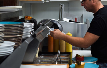 Restaurant kitchen employee reading chit with customer food order