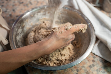 Young female preparing vegetarian bread dough on the table. Vegetarian meal concept. Close up.